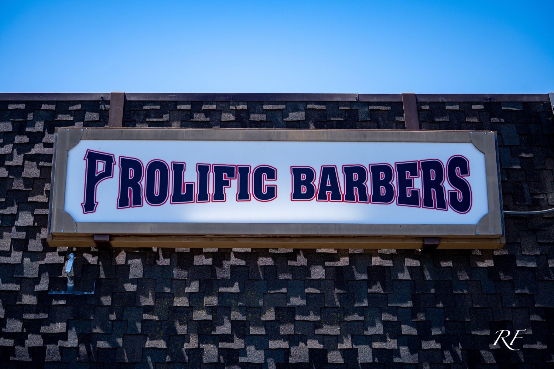 Prolific Barbers storefront sign